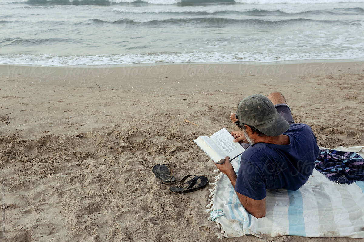 Man reading at the beach from above