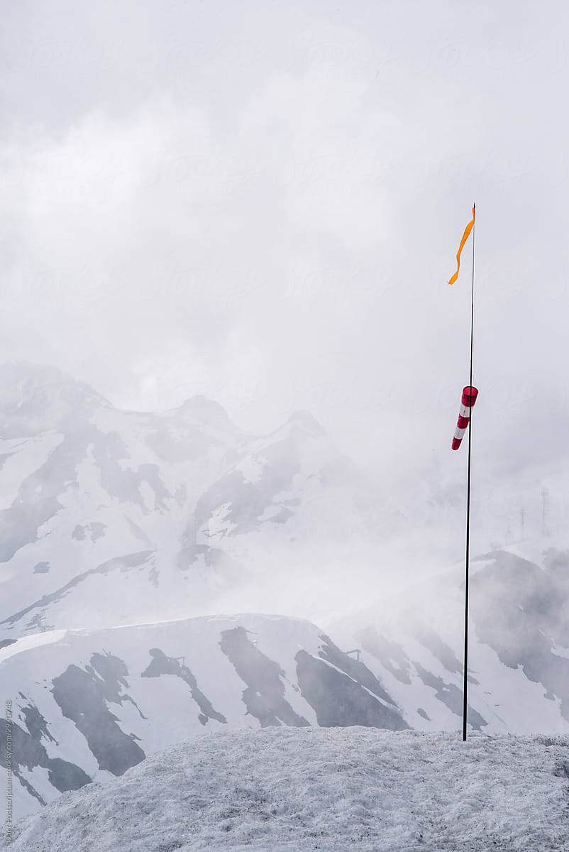 Mountain winter landscape\
with a wind sock in the foreground