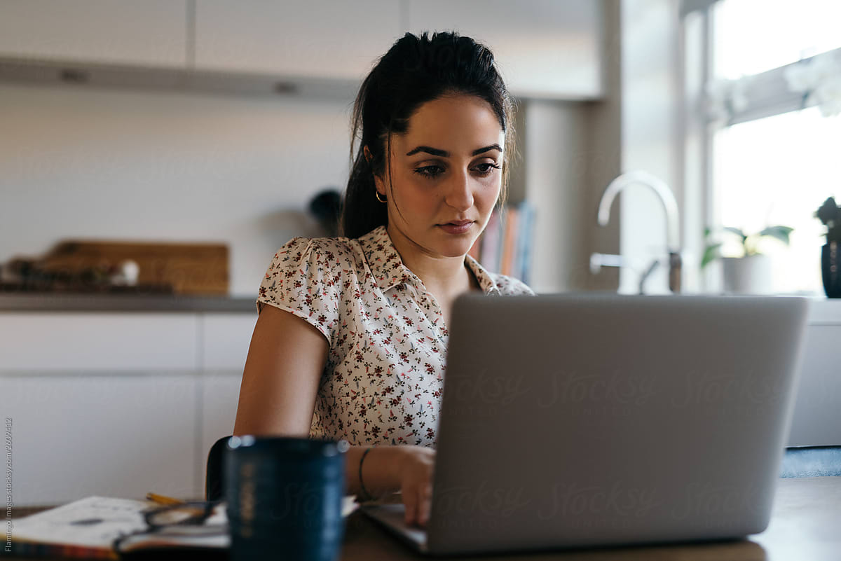 Woman at laptop in kitchen