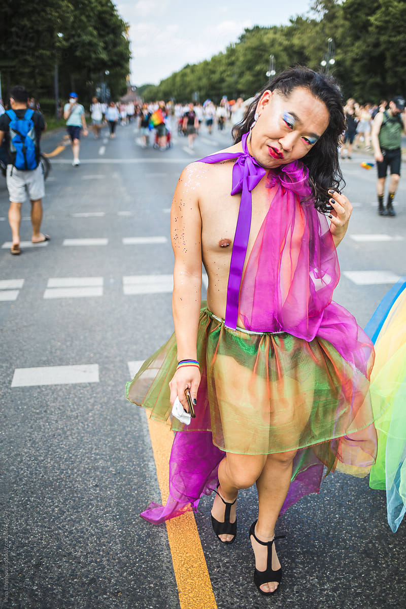 Cute asian man in a rainbow coloured chiffon dress on a Pride