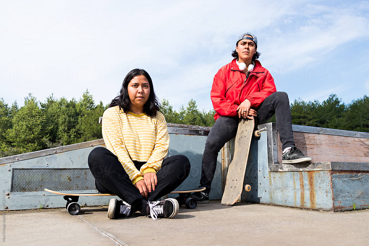 Portrait Of Two Skateboarders Sitting On Ramps
