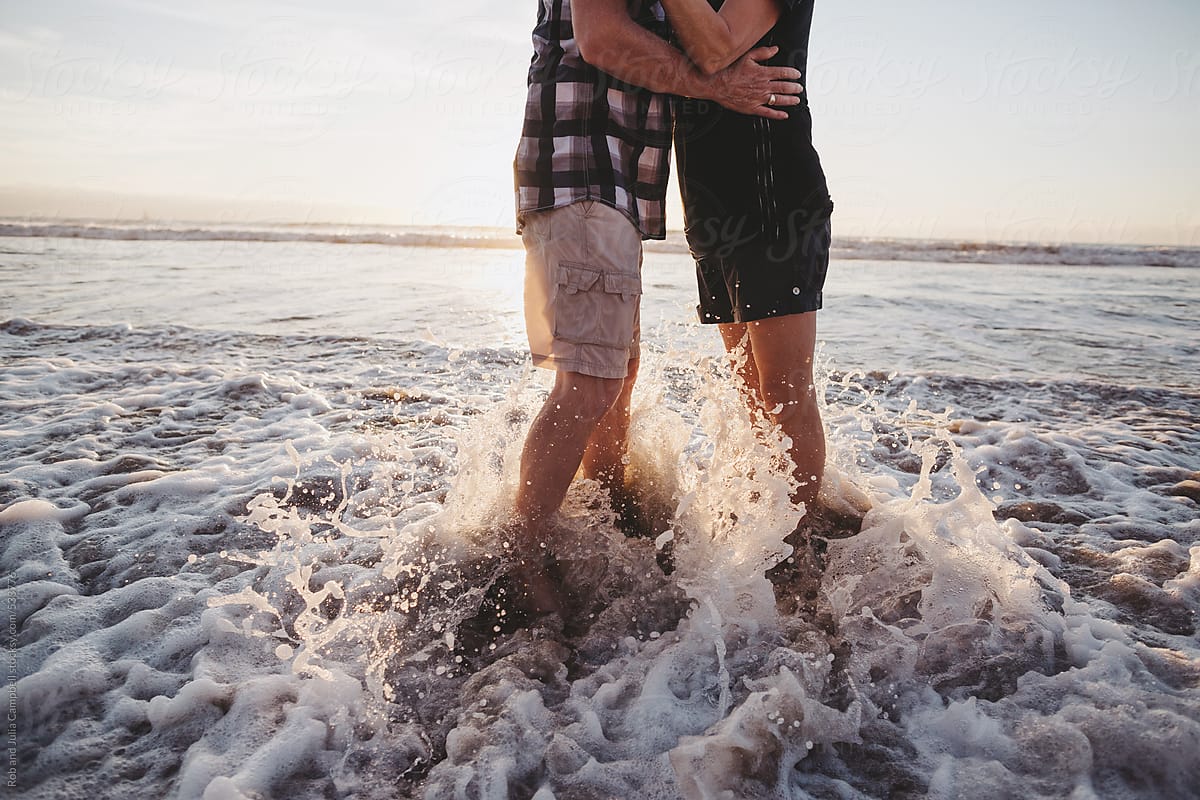 Affectionate Middle Aged Couple Hug Together Outside On Ocean Beach By Stocksy Contributor