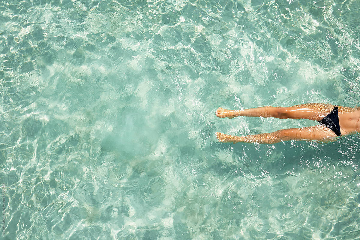 Woman floating in ocean water on vacation