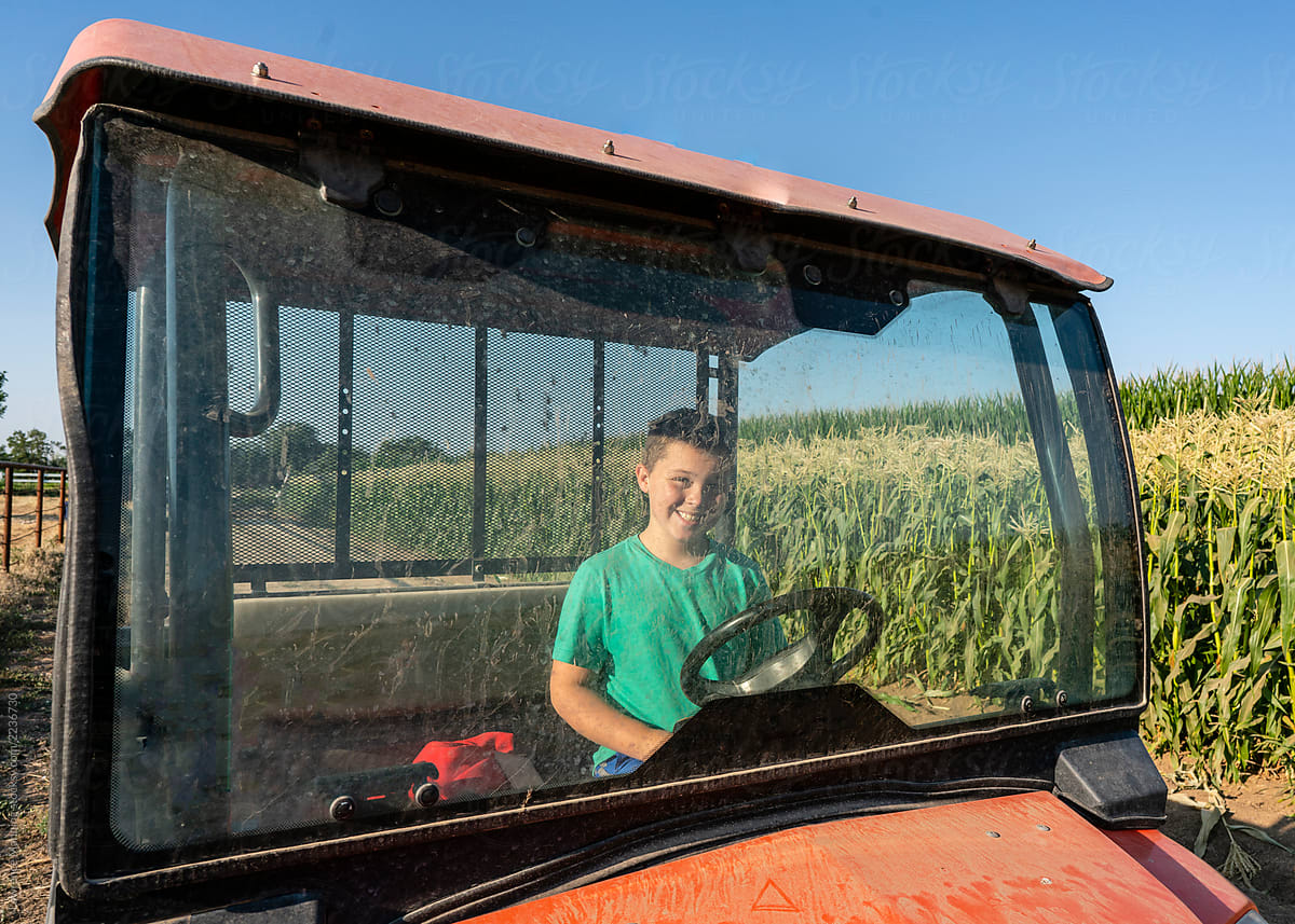 Young man driving farm vehicle