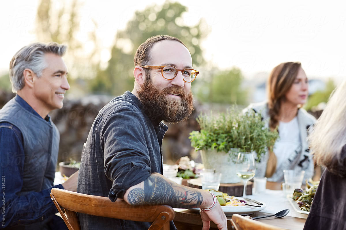 Portrait of man at dinner party with friends outdoors