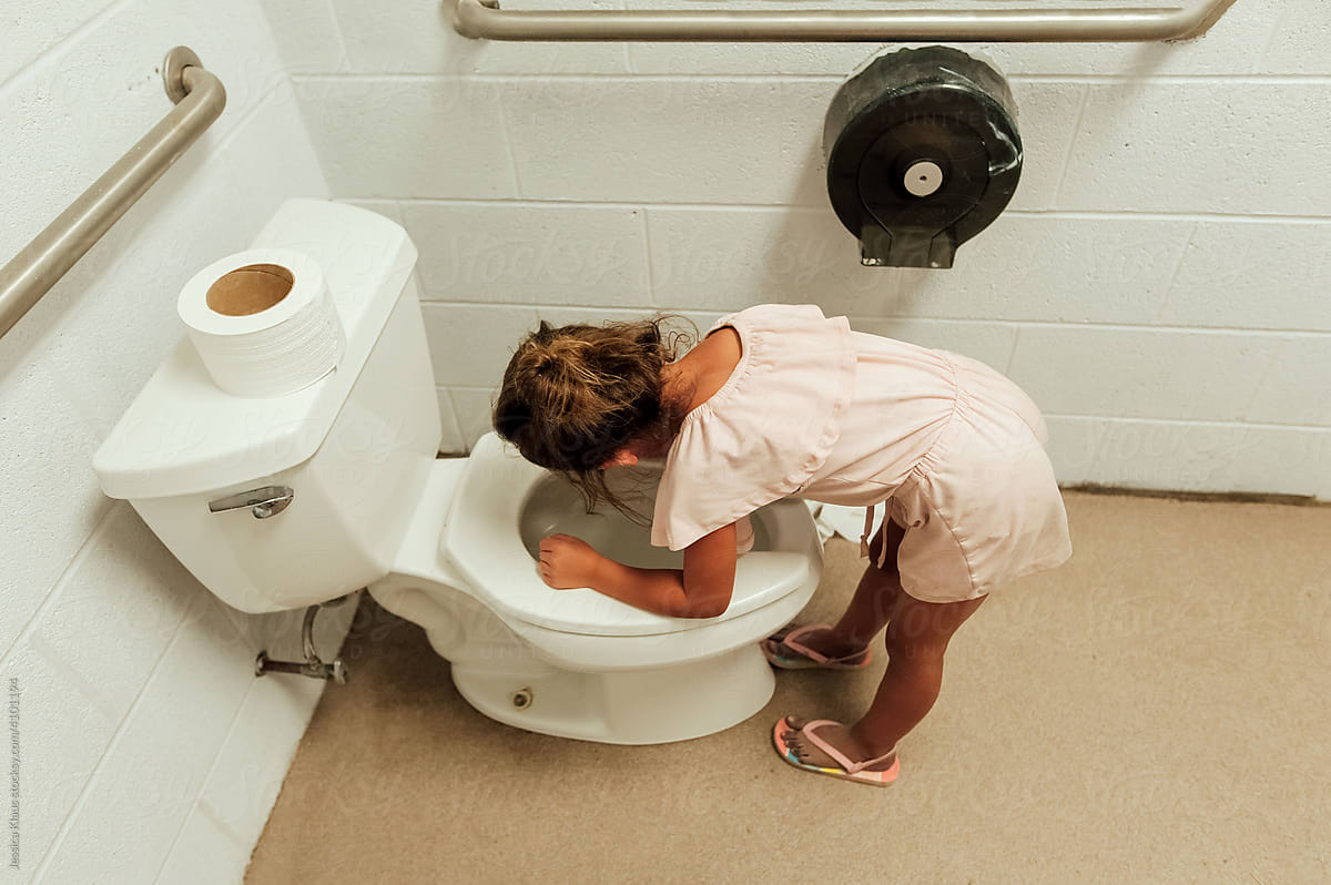 Girl puking in toilet.