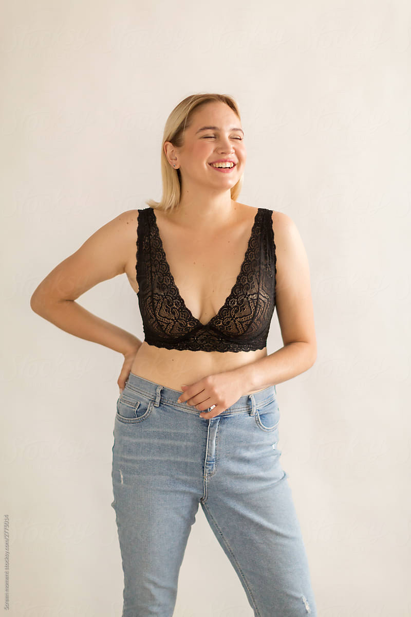 Portrait of a beautiful blonde woman in black bra on a white background. Beautiful blonde  plus size  woman  smiling