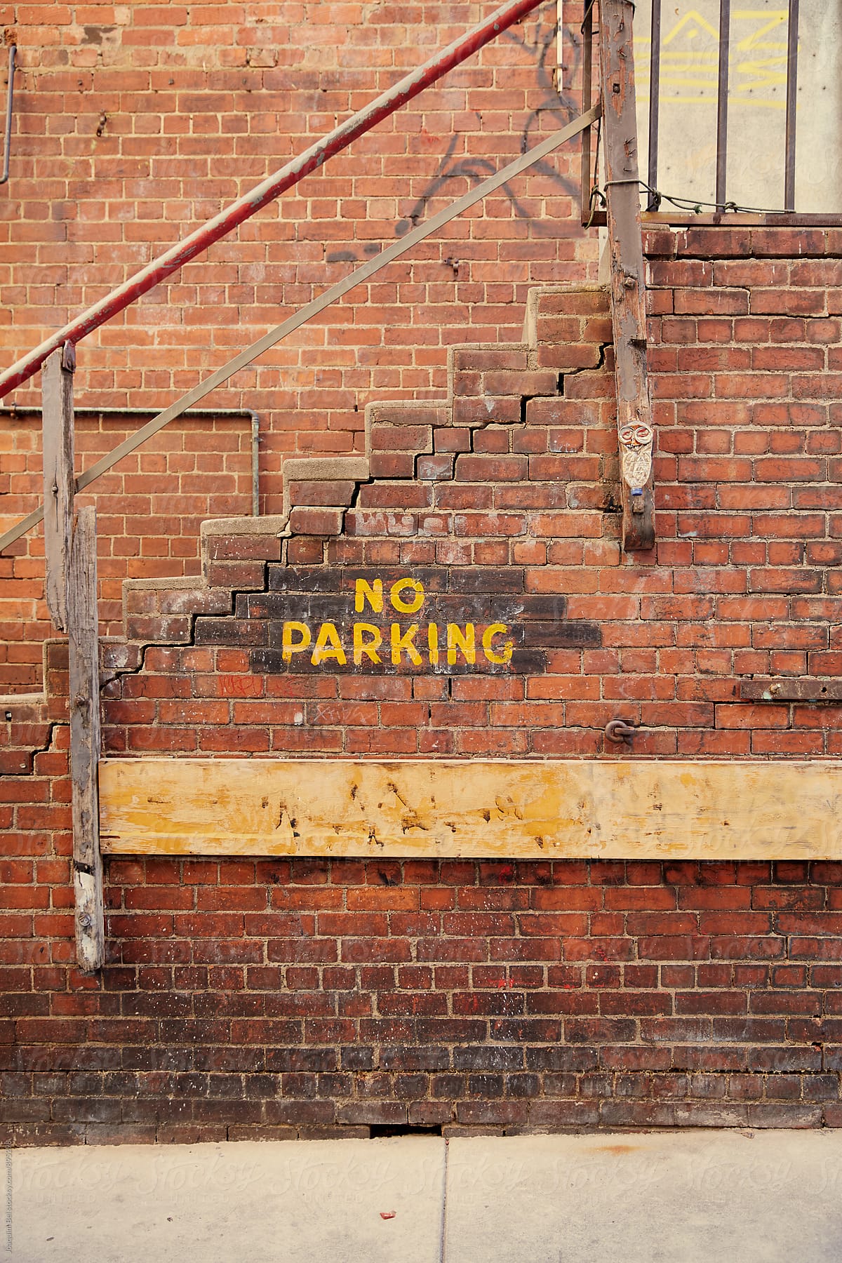 Old brick wall with a No Parking sign
