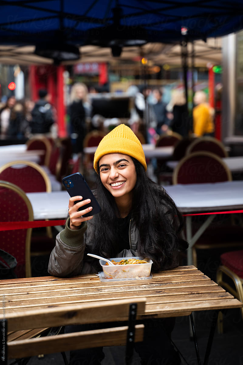 Happy Woman Using Phone While Eating