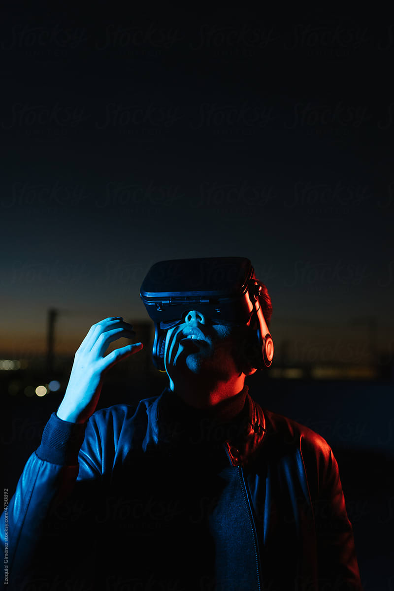 Man playing VR videogame at night