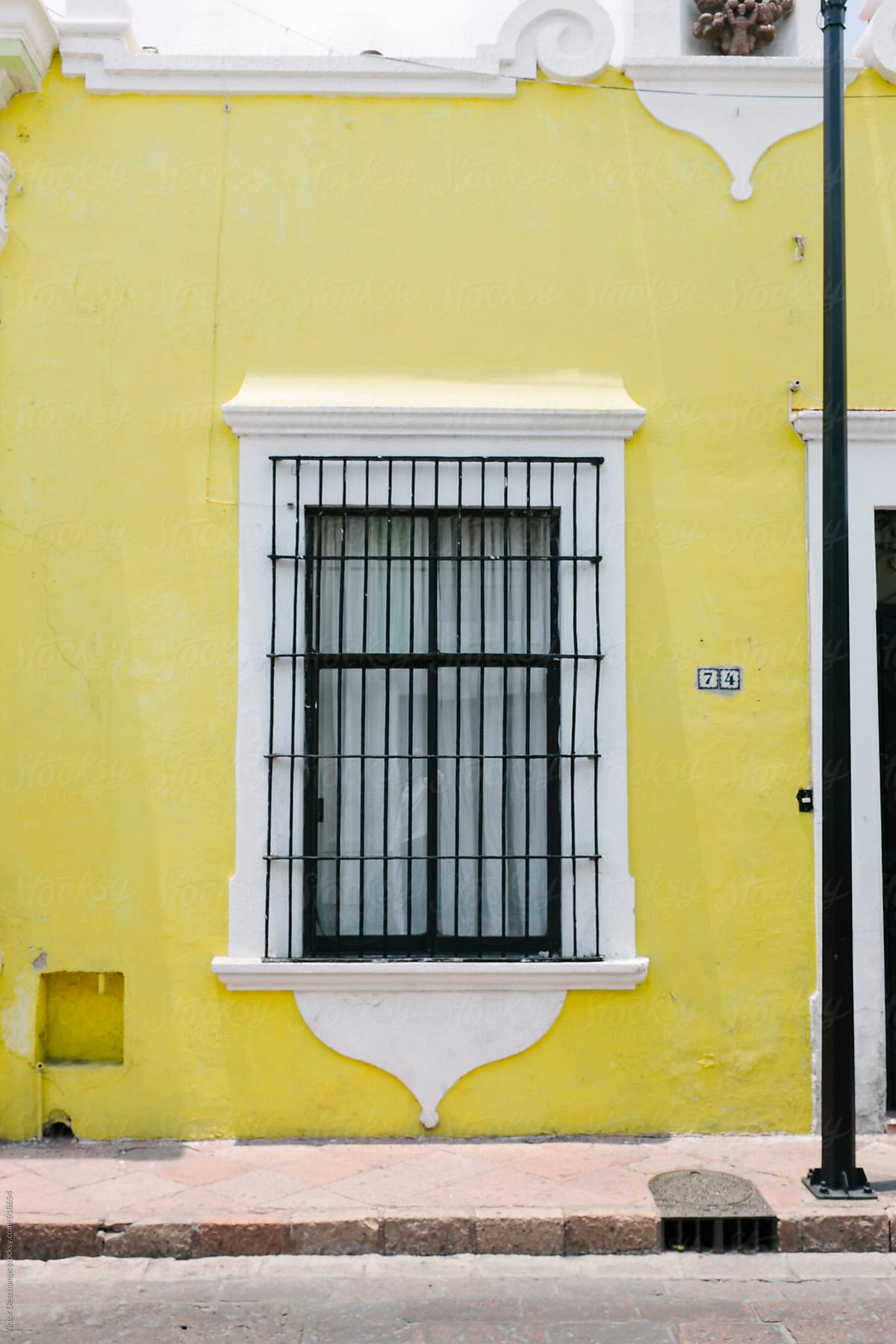 Yellow facade of a small colonial house.