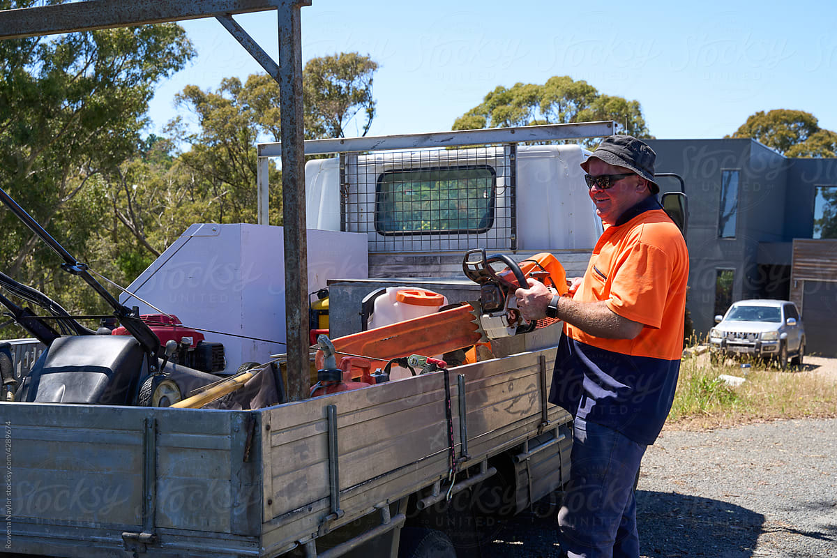 Tradie putting chainsaw into truck