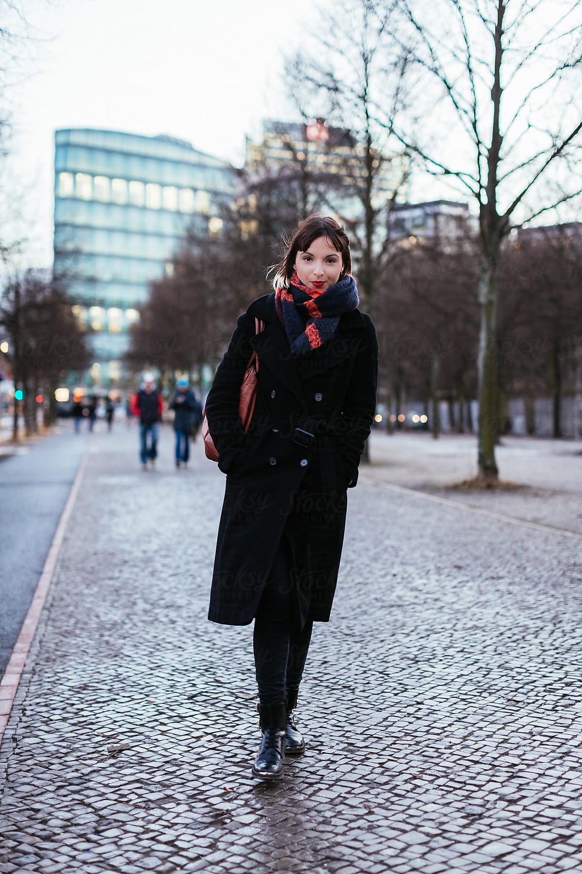 Woman walking on a walkway in the city in winter