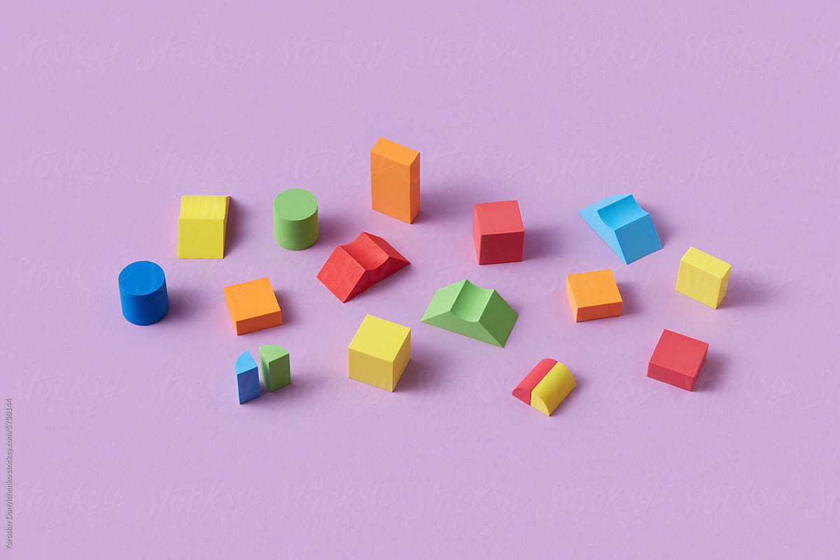 Different colorful wooden blocks scattered on purple background