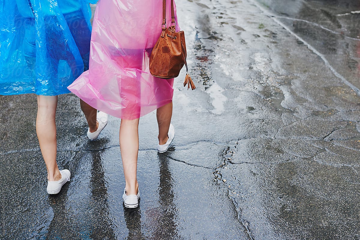 girl friends explore city in ponchos in rain travel together hav