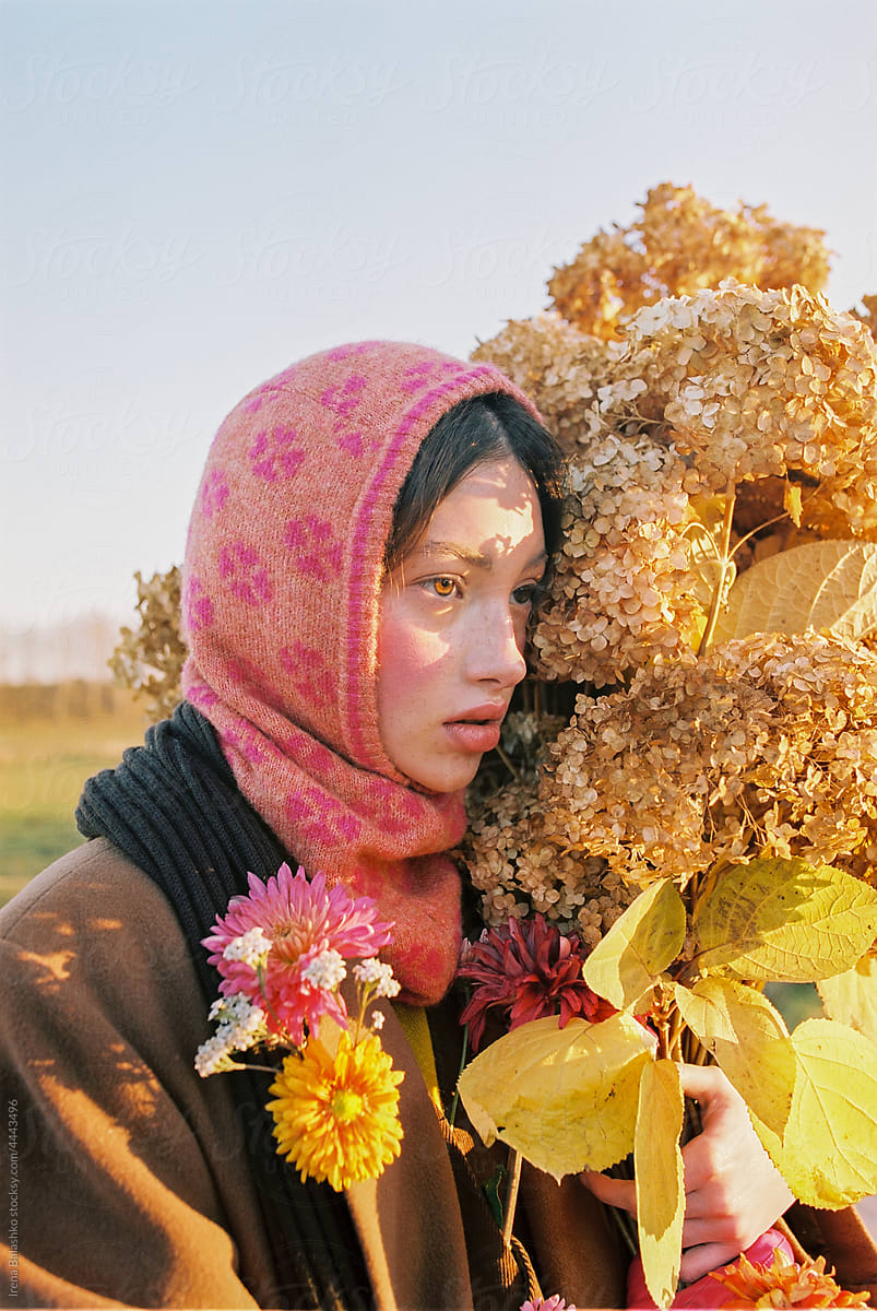 girl with freckles holds autumn flowers