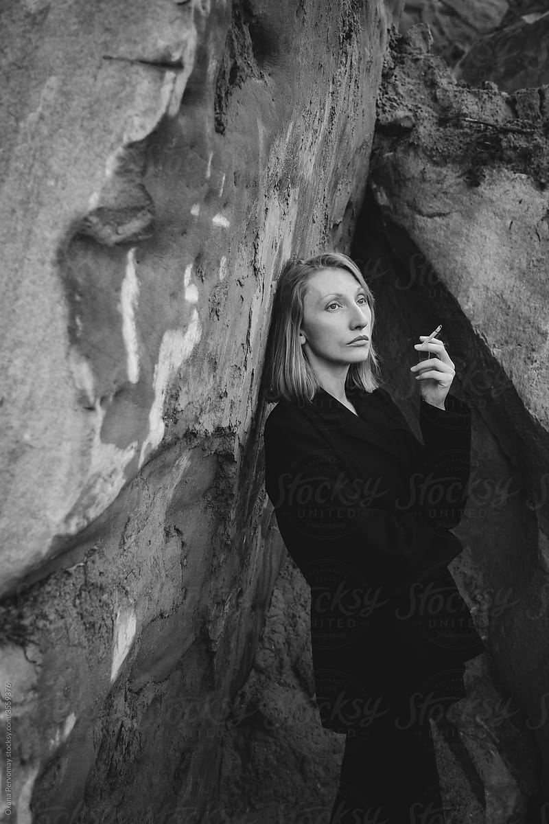 Lady smoking in the rocks.