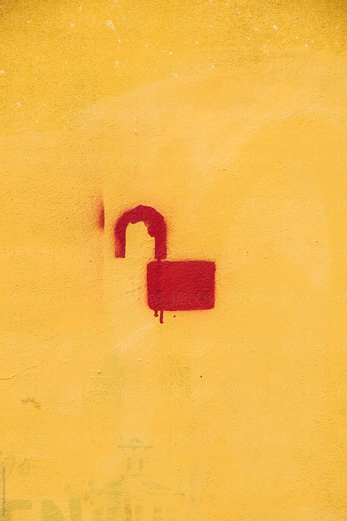 Unlocked Lock Stencil Graffiti on Yellow Plaster Wall