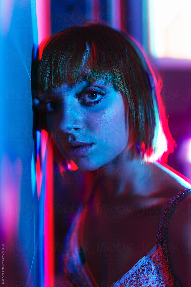 Beautiful female model with red and blue lights on her skin