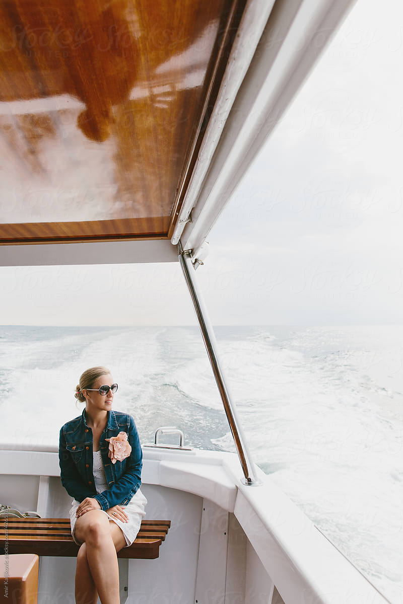 Woman Sitting at Bow of Boat Traveling at Sea