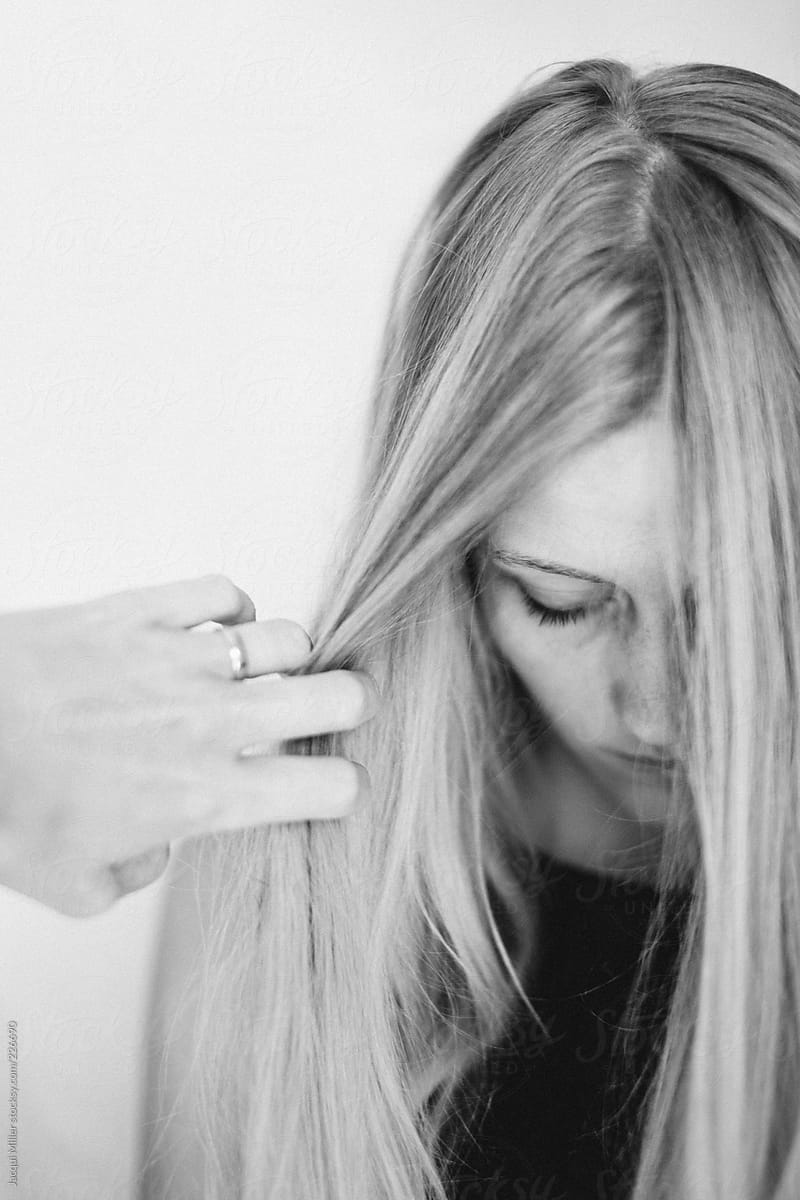 Mother's hand gently draws back the hair from her daughters face