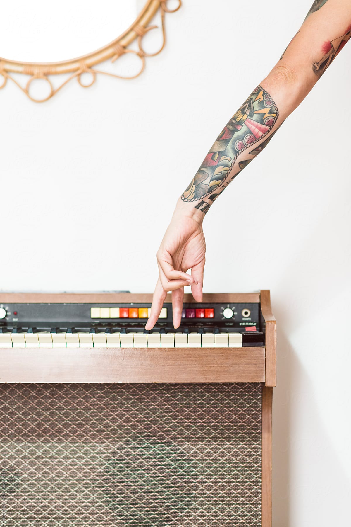 Tattooed hand playing old piano