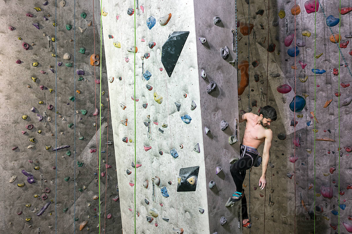Rock climber high on an indoor climbing wall
