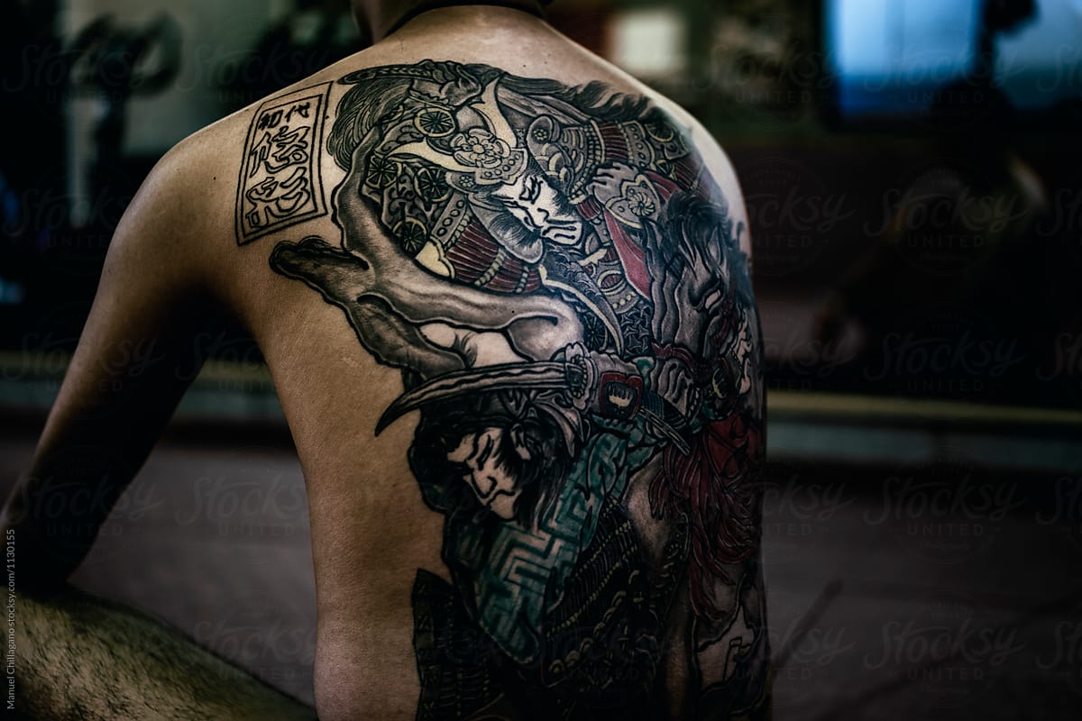 Japanese man presenting a historical motif tattooed on his back
