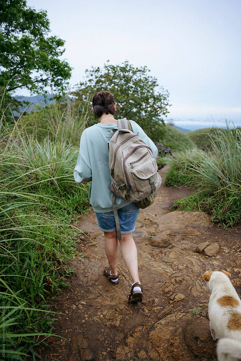A woman enjoys a trip in the mountains with her dog