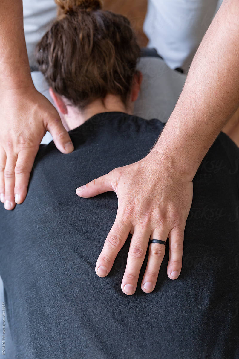 Chiropractor\'s hands on a woman\'s back.