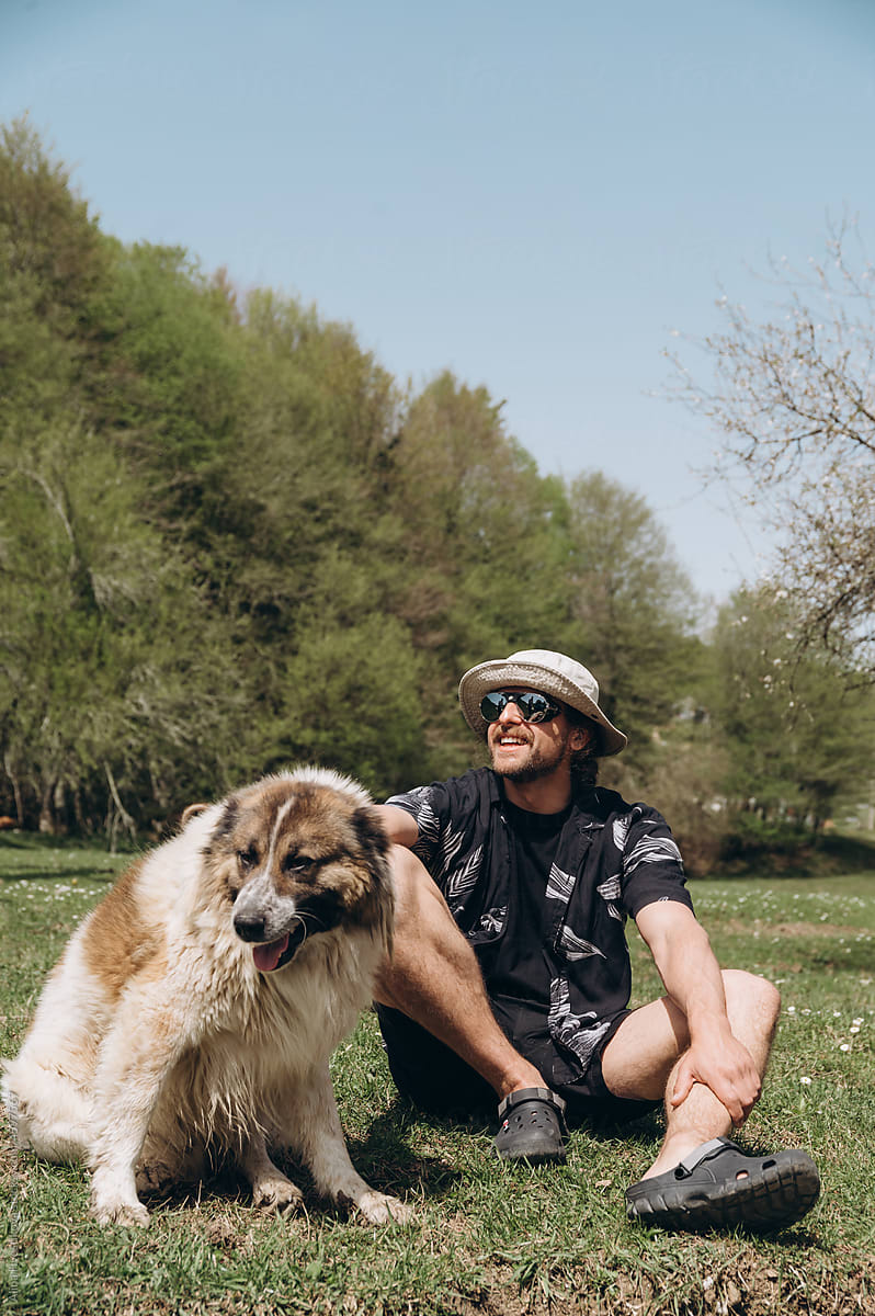 Man with Caucasian shepherd dog on lawn