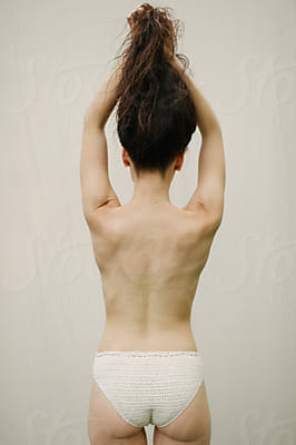 Skinny Girl Wearing White Bra With Boney Spine Showing by Stocksy  Contributor Jess Craven - Stocksy