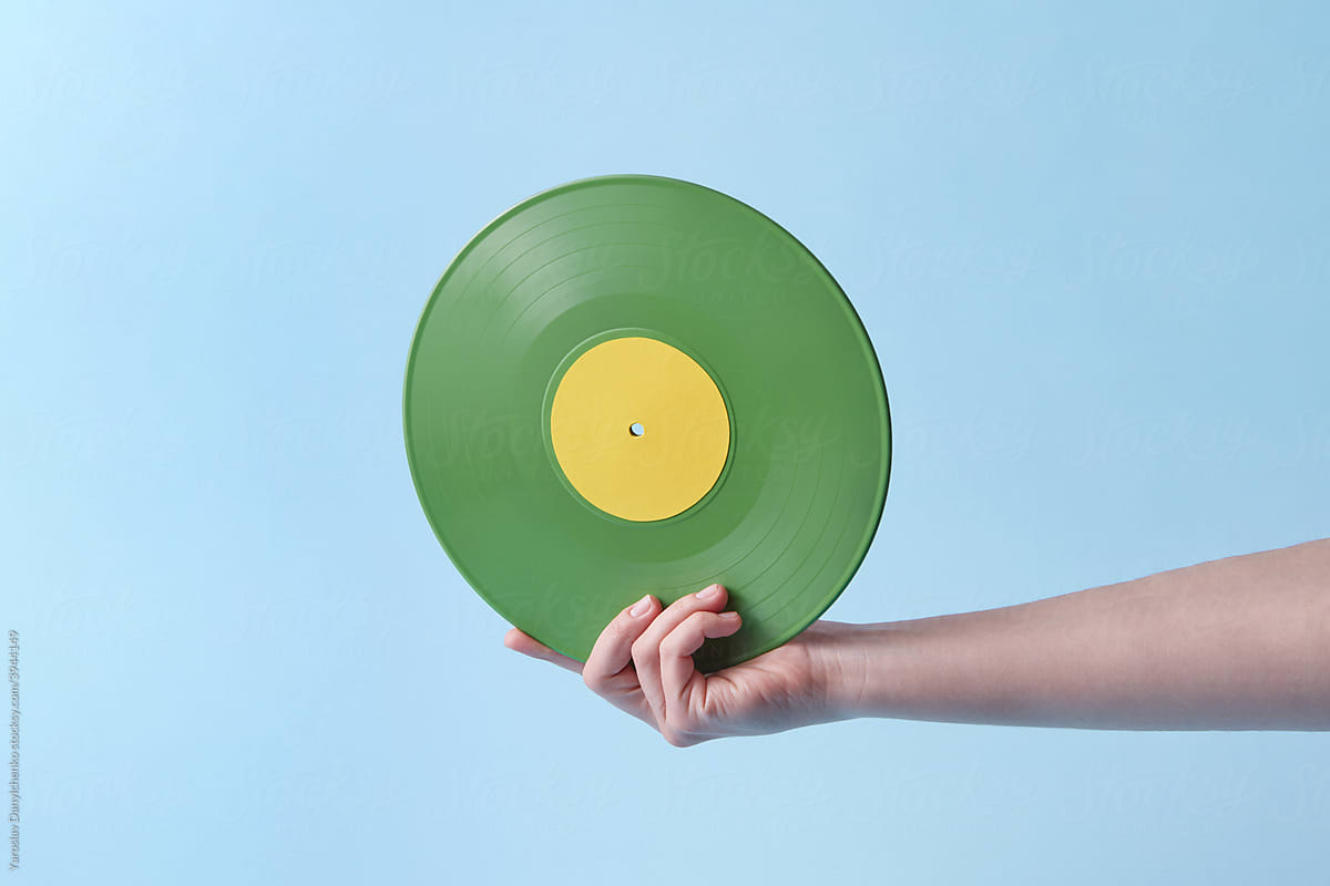 Woman holding old-fashioned green vinyl record