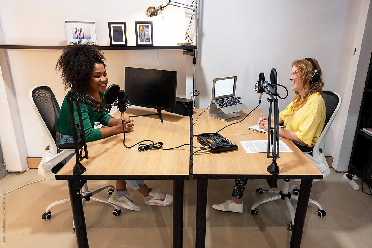 Happy diverse radio hosts recording podcast in studio