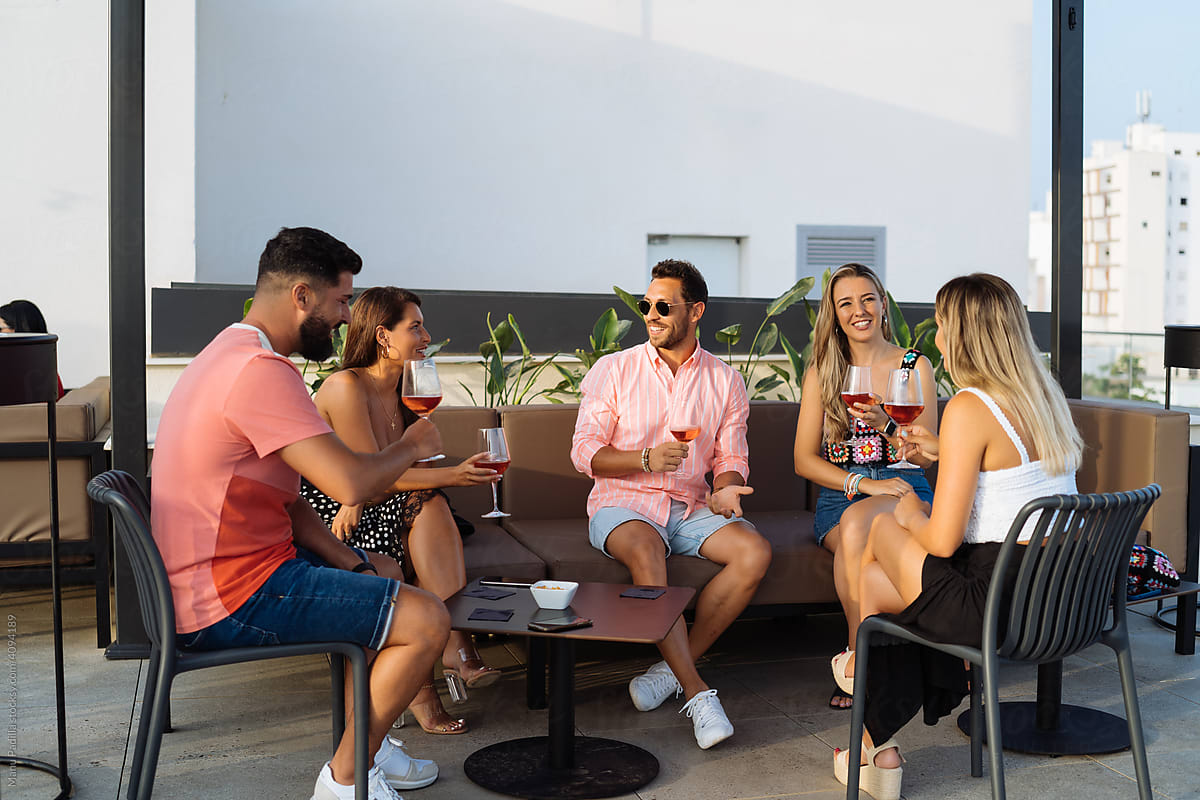 Friends drinking wine on summer terrace