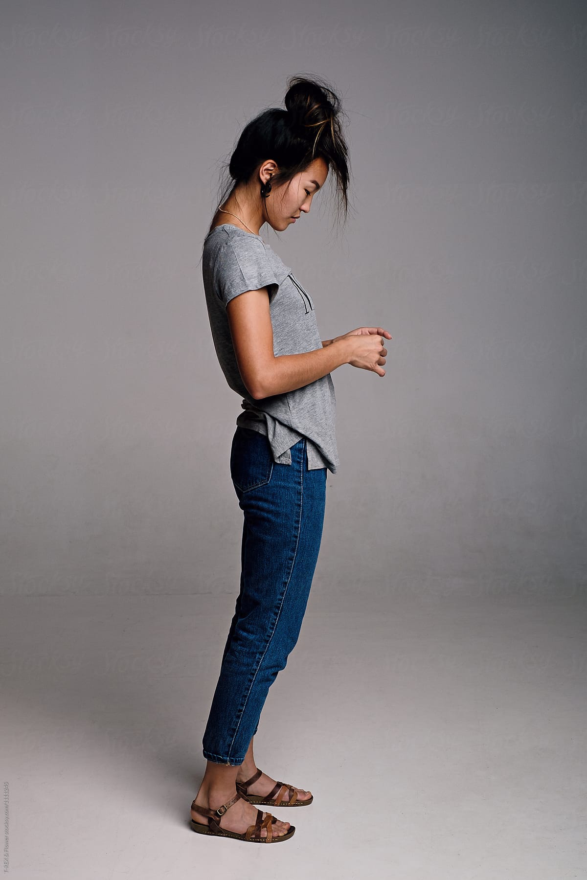 Side view of Asian girl in casual clothes with messy hair in tail