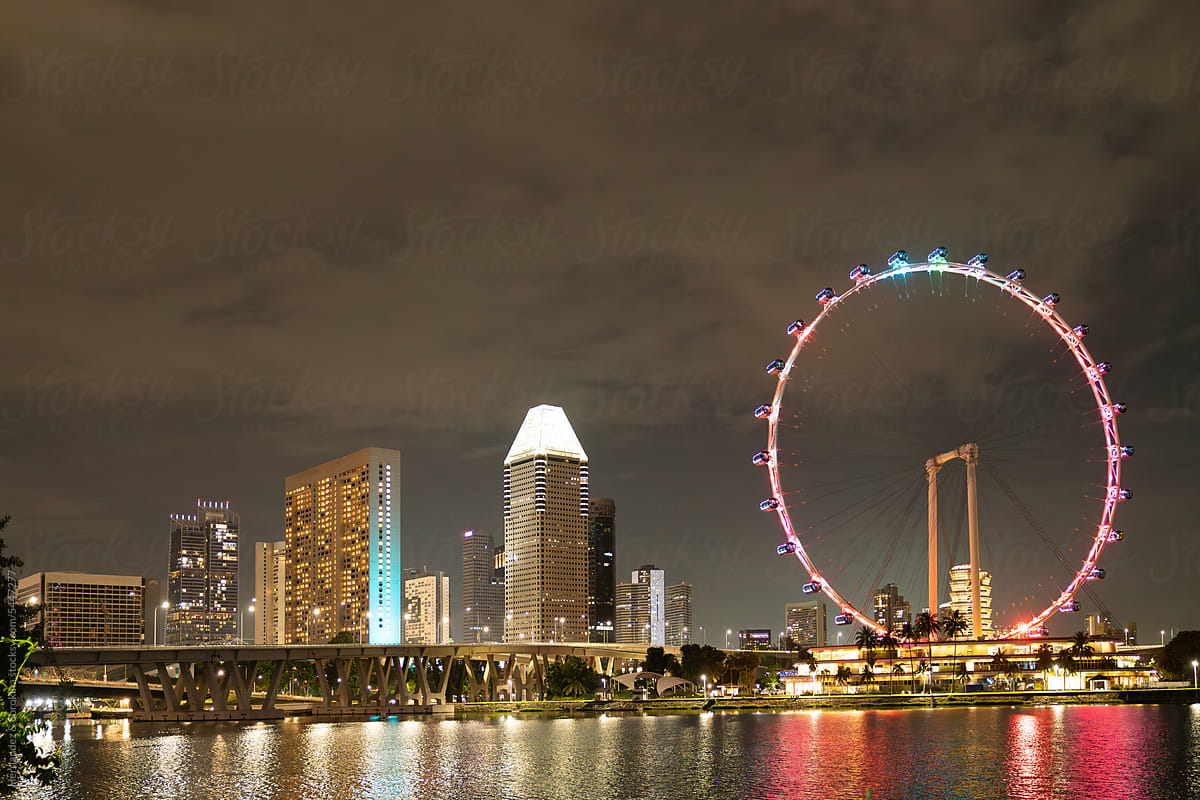 Ferris Wheel And Skyscrapers Of Singapore At Night
