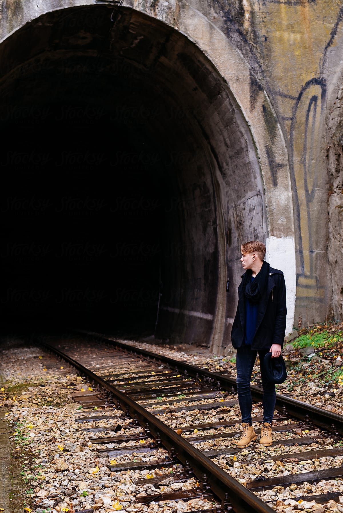 Handsome young man posing on train tracks