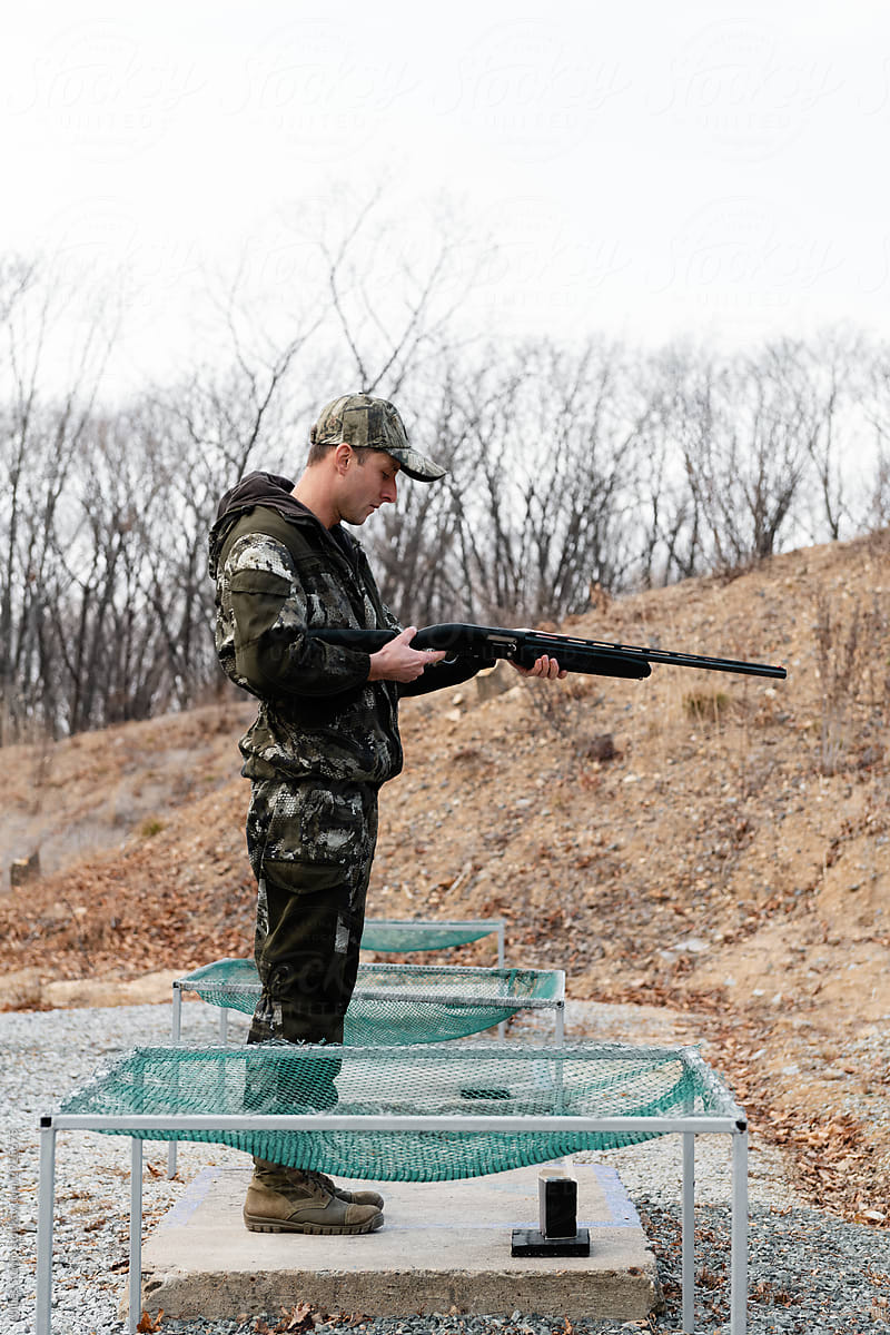 Shooter examining rifle on firing ground