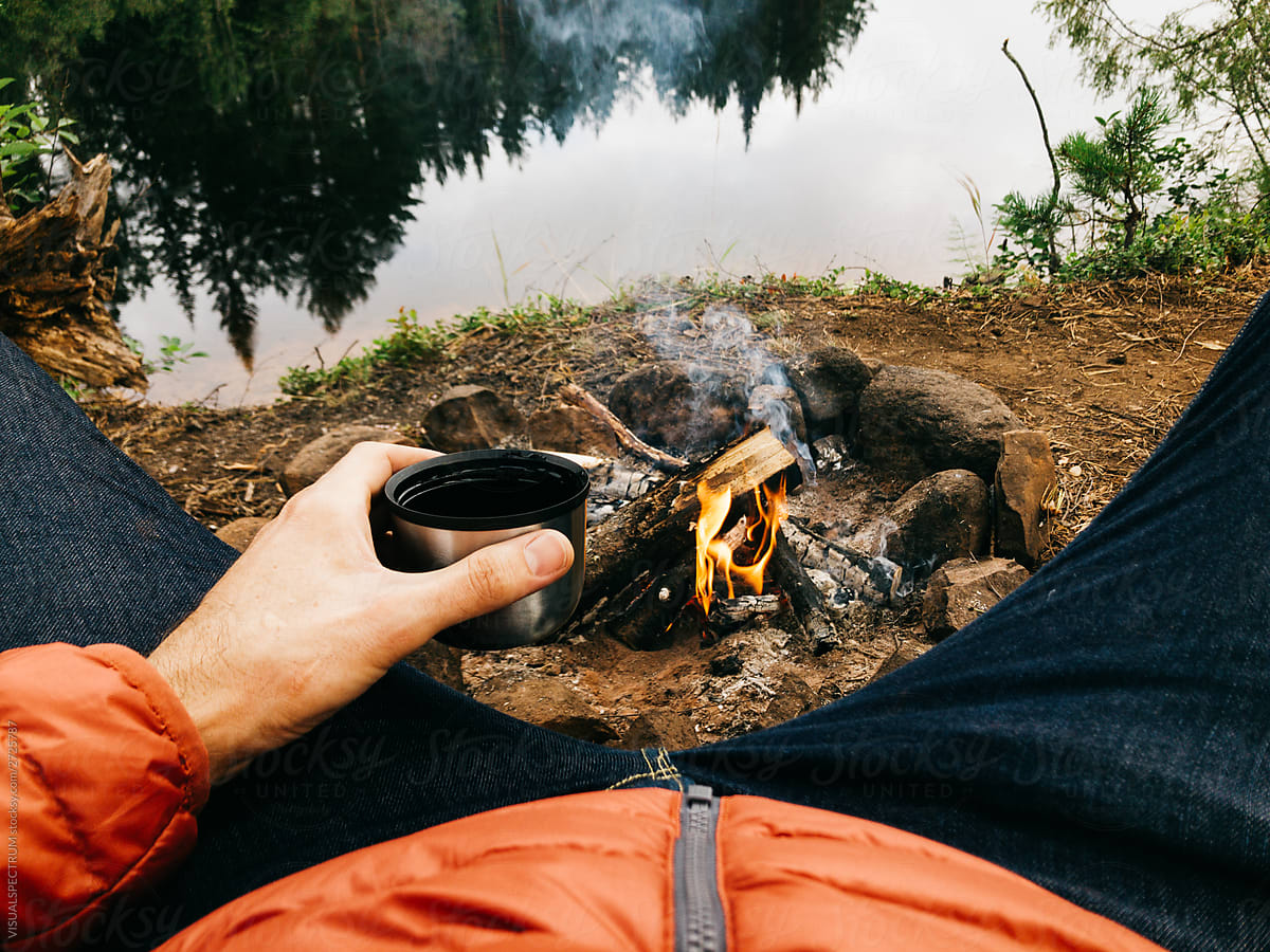 Anonymous Man Drinking Hot Tea by Campfire