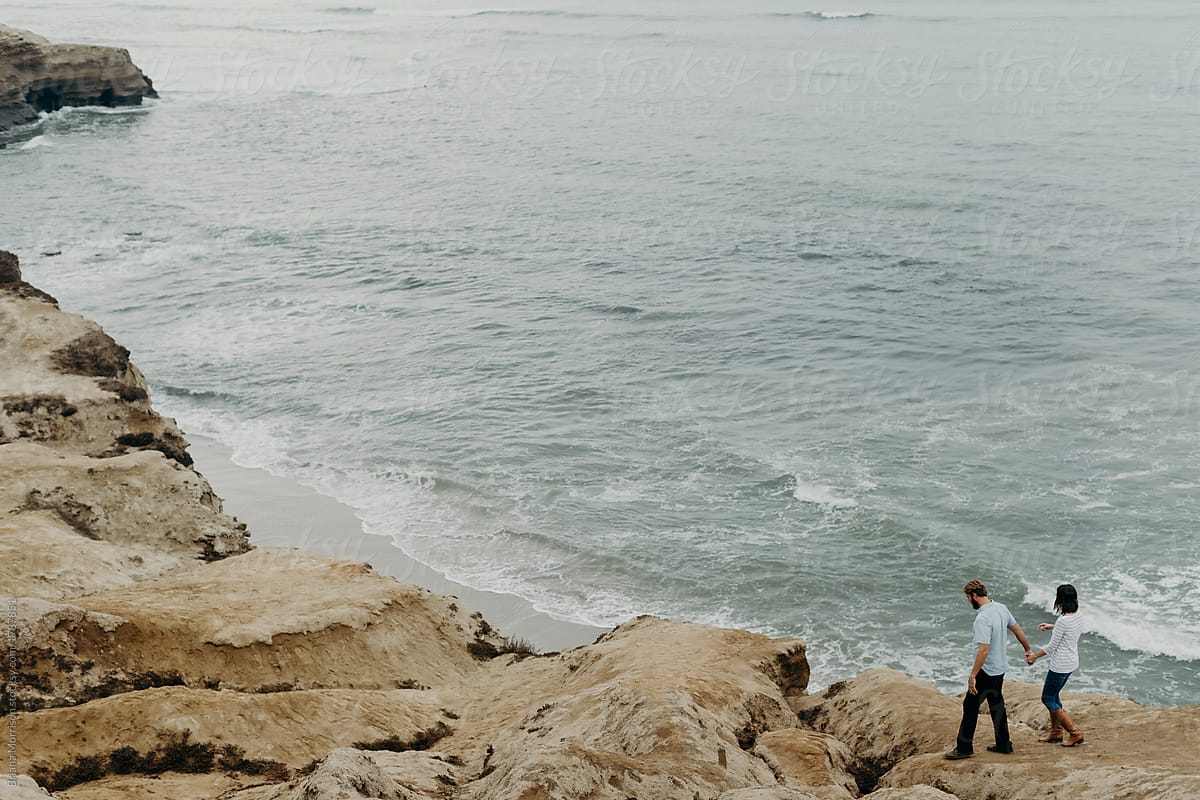 A Couple Walking Along Ocean Cliffside