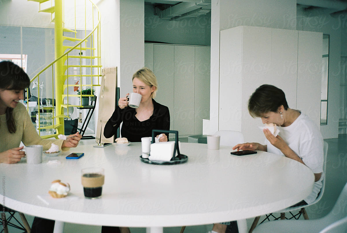 Three women at the table during the coffee break in office