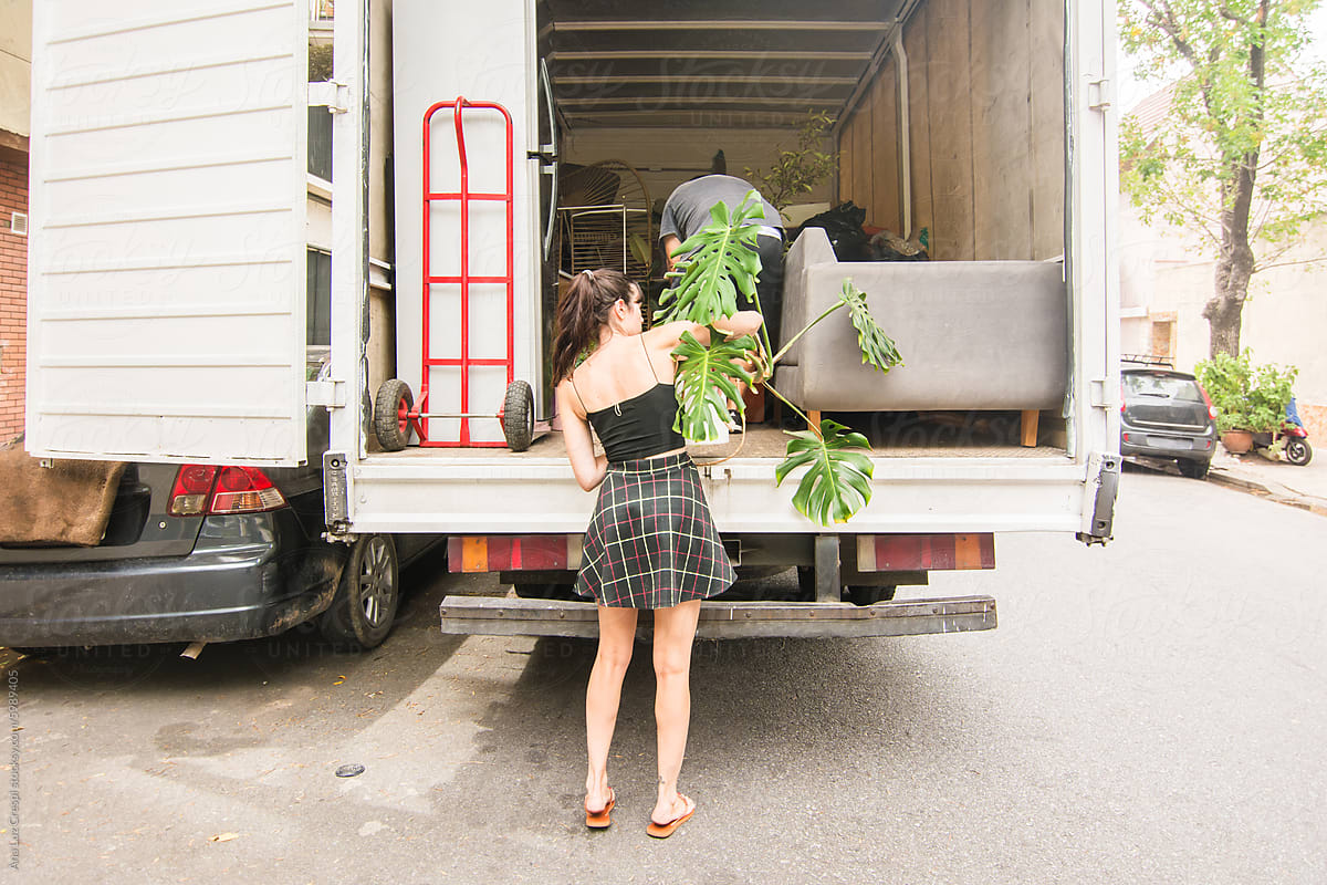 Woman loading houseplant into movers truck