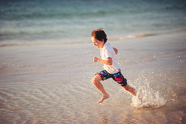 Boy Making A Sand Angel At The Beach At Sunset by Stocksy Contributor Angela  Lumsden - Stocksy