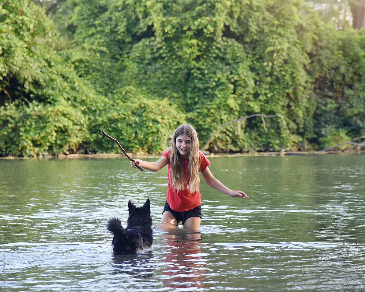 Girl Playing with Dog in Water Outside