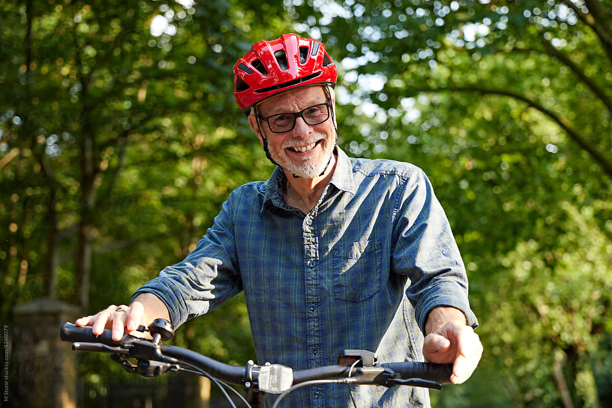 Older Man with glasses rides Mountain bike on leisure cycle