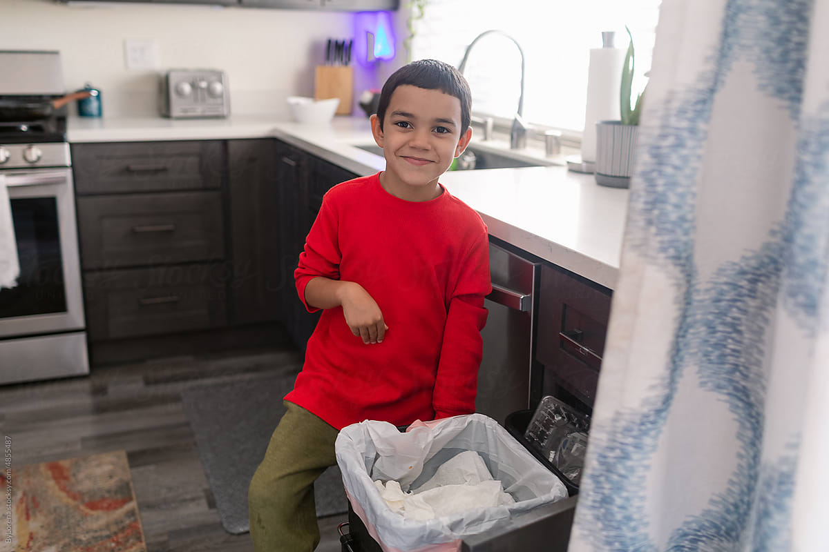 Young boy recycling in the kitchen