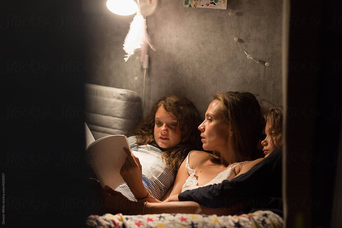 daughter reads a book near mom