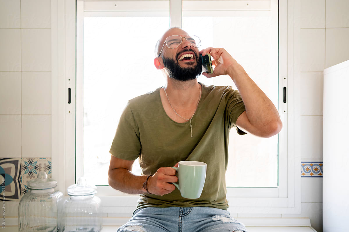 Man smiling calling by phone at kitchen
