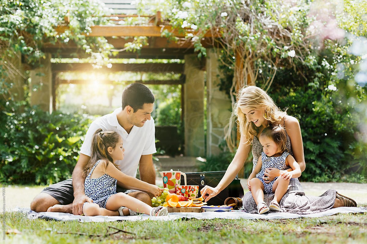 Young Couple Having A Picnic With Their Two Daughters By Image Supply